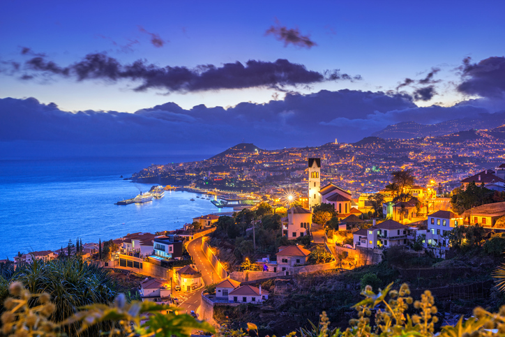 Elevated view on the district of São Gonçalo and the cityscape, harbour and surrounding mountains of Funchal on the Portugese Island of Madeira.