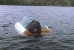 An overturned boat in the middle of a lake.