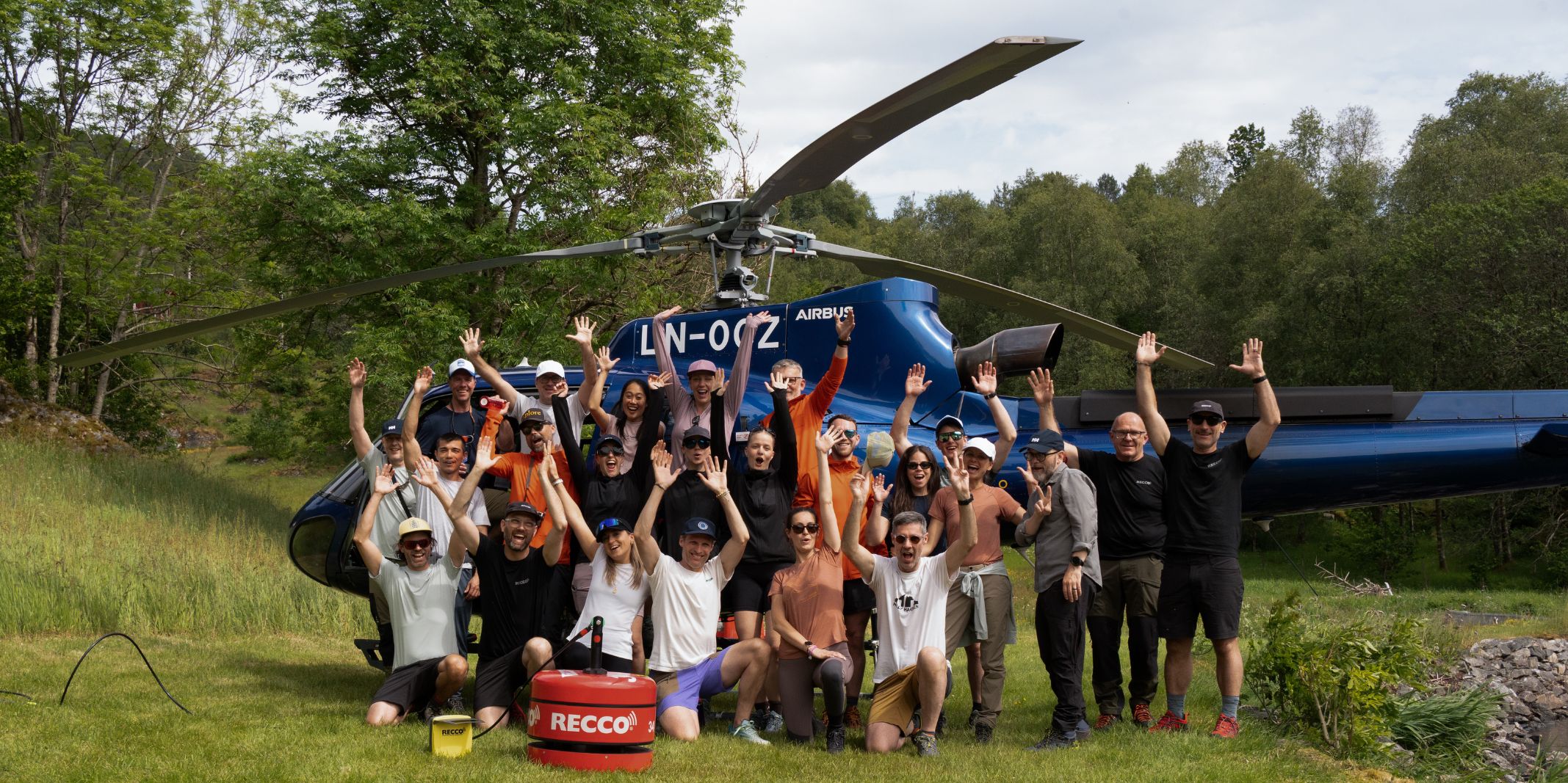 group of people outside a helicopter on a helly hansen press trip in norway
