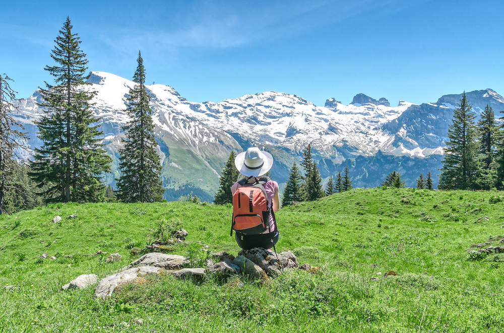 woman sitting on a rock with mountains behind