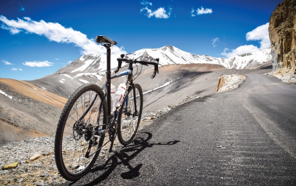 bike standing next to road with mountains in background himalayan highway credit matt westby