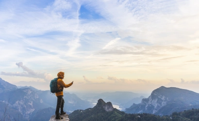 hiker on summit with smartphone in hand