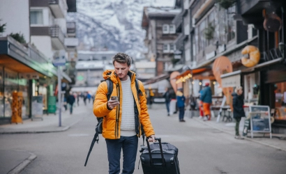 man with duffle bag in alpine village