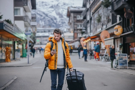 man with duffle bag in alpine village